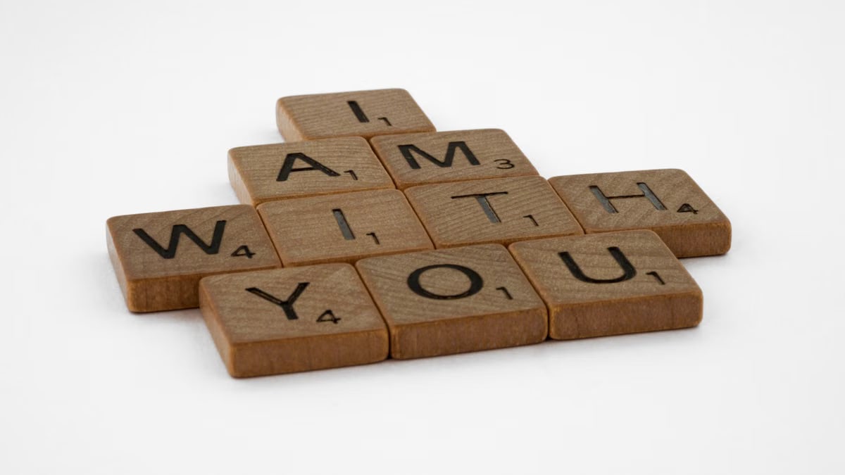 Scrabble tiles spelling 'I Am With You' on a clean white background.